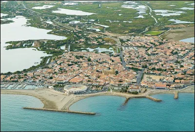 Quelle est cette petite ville de 2 200 habitants, située sur le rivage de la Camargue, à environ un kilomètre à l'est de l'embouchure du Petit-Rhône ?