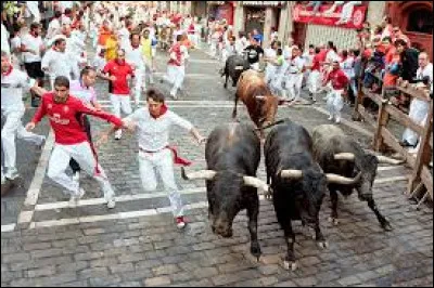 Quelle fête traditionnelle espagnole implique des courses de taureaux ?