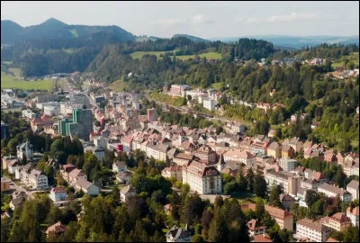 Quelle est cette ville suisse de 10 000 habitants, située dans le massif du Jura à la frontière française, connue pour son industrie horlogère ?