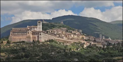 Quelle est cette ville de 28 000 habitants, située en Ombrie dans une région de collines, connue pour sa basilique et les fresques de Giotto ?