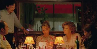 Dans ''Un air de famille'', quel acteur est assis en arrière-plan, derrière Catherine Frot ?