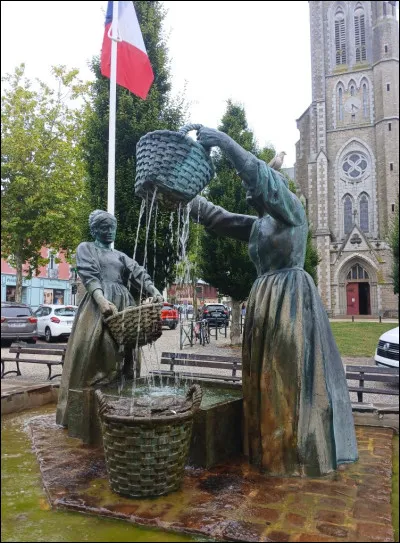 Il n'est pas du tout commun de rencontrer une sculpture qui représente des femmes au travail. Telle, cette fontaine de bronze de 1999, qui rend hommage à un métier bien spécifique, aujourd'hui disparu. Que représente cette uvre du sculpteur Jean Fréour et dans quelle ville peut-on l'admirer ?