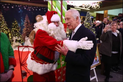 Avec qui le Père Noël pose-t-il sur l'image ?