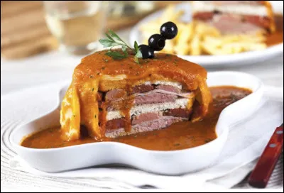 Quelle est la sp&eacute;cialit&eacute; culinaire de la ville de Porto, &agrave; base de saucisse, de viande, de jambon, le tout recouvert de fromage fondu et d'un oeuf ?