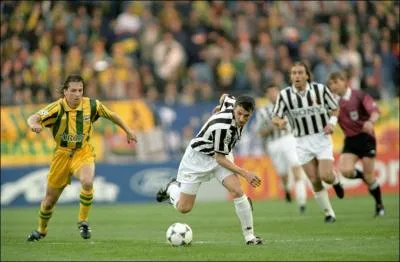 Qui est ce joueur au maillot ray de noir et blanc menant le ballon ?