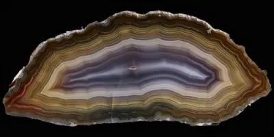 Je suis une pierre précieuse que l'on taille en tranches. Je suis une variété de calcédoine. Quel est mon nom ?