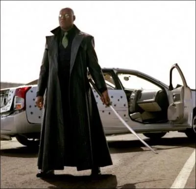 Dans quel film de la saga 'Matrix' voit-on Laurence Fishburne devant une voiture de police crible d'impacts de balles aprs une course-poursuite mmorable sur une autoroute ?