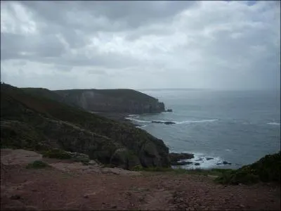 De combien les falaises rouge, noir et gris surplombent-elles la mer (environ) ?
