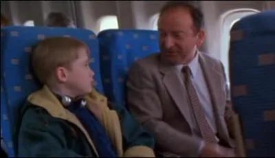 Lorsque Kevin prend l'avion de New-York par inadvertence, il s'assied  ct d'un voyageur parlant en quelle langue ?