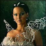 Que représente la magnifique robe blanche dans laquelle Katniss se présente devant le public ?