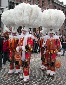 Salut la Belgique ! Comment s'appellent les personnages qui défilent dans un costume en toile de jute bourré de paille et garni de grelots. Ils portent un panier d'oranges qu'ils lancent au public.
