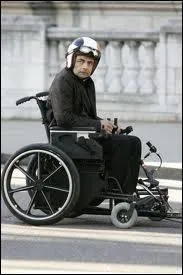 Quand Johnny veut prendre l'ascenseur pour un fauteuil roulant, quel objet sort-il pour monter en premier ?