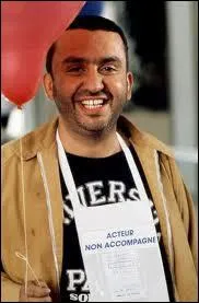 Simon Jérémi (Dominique Farrugia) attend avec son ballon rouge et sa pancarte qu'on vienne le chercher à l'aéroport. Quel est le titre de ce film culte ?