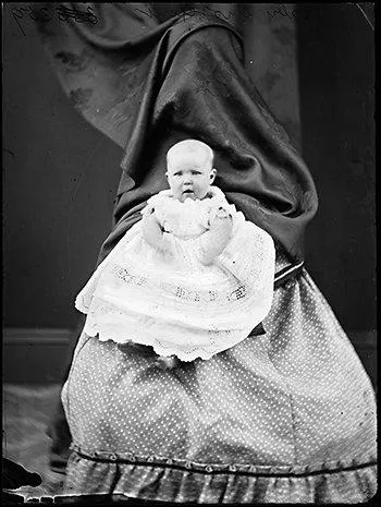 Sur cette photographie comme sur d'autres de la mme poque, la femme qui tient l'enfant est recouverte d'un drap ou d'une nappe. Pourquoi ?