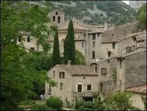Au confluent du Verdus et de l'Hrault, ce village s'est dvelopp autour d'une abbaye construite en 804 afin d'y abriter un morceau de la Croix offert par Charlemagne. Comment s'appelle-t-il ?