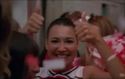 A qui Santana fait-elle signe quand le Glee Club revient vainqueur au lyce ?