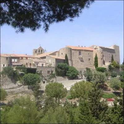 Quel est ce village mdival fortifi bti en haut d'une colline  plus de 250 mtres d'altitude, autour de son chteau et o est construit un circuit automobile ?
