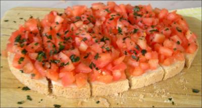 Il s'agit gnralement d'une tartine de pain grille frotte d'ail, arrose d'huile d'olive et garnie de petits morceaux de tomates, assaisonne de basilic :