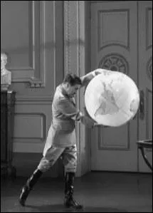 Dans la scne clbre du globe terrestre o Chaplin joue avec celui-ci, comment finit la scne ?