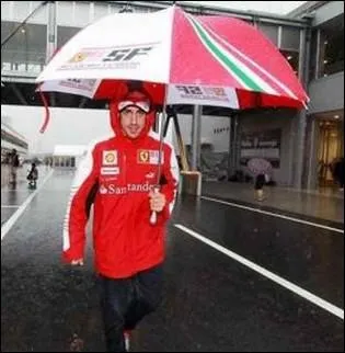 Quel pilote automobile s'abrite sous ce superbe parapluie publicitaire ?
