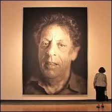 Quel peintre et photographe hyperraliste peint d'immenses portraits au rendu photoraliste ?