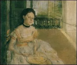 Femme assise sur un balcon.