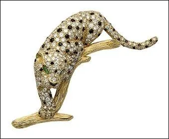 Sur une branche en or cisel. Le corps est serti d'onyx, meraudes et diamants. Vous allez succomber au regard du bel animal tachet de rosettes.