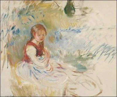 Petite fille assise dans l'herbe.