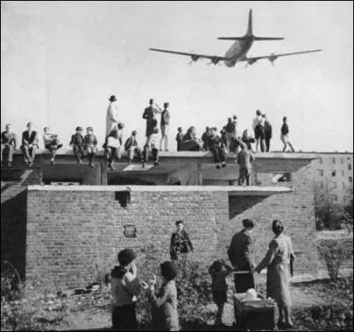 Quel est le rsultat direct du blocus de Berlin, organis par l'URSS en 1948 et 1949 ? (photo : Avion survolant Berlin durant le blocus)