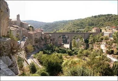 Je suis un magnifique village du dpartement de l'Hrault, tapi sur un promontoire model par deux canyons creuss dans le calcaire, qui suis-je ?