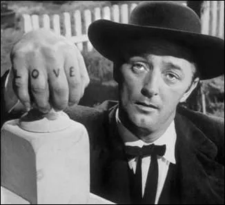 En quoi Robert Mitchum se dguise-t-il dans  La Nuit du chasseur  pour faire main basse sur le magot cach par son ancien camarade de cellule ?