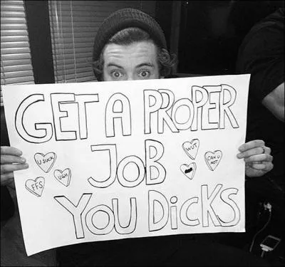 Sur l'affiche d'une fan 'Get A Proper Job You Dicks', quel est le mot barr� ?