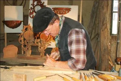 Un sculpteur sur bois en plein travail.