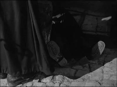 A qui appartiennent les solides chaussures en premier plan, qu'on devine sous la longue robe noire... ?