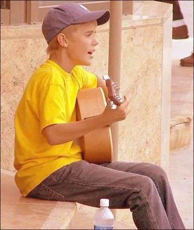 Sur cette photo, devant quel thtre Justin joue-t-il ?