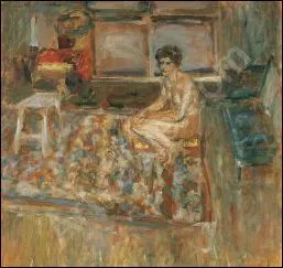 Nu assis sur un tapis orange.