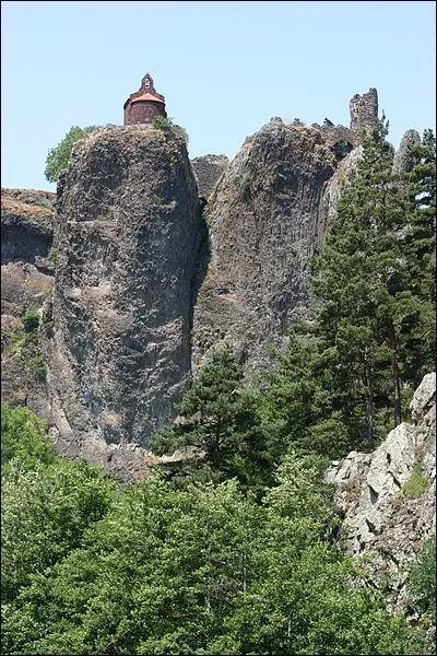Quel est cet étonnant village fortifié s'ouvrant par une porte de basalte et dominé par une étrange forteresse en ruine situé dans le département de la Haute-Loire ?