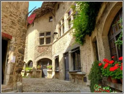 Situé au sommet d'une colline, ce village de l'Ain fait cercle autour de sa place ombragée, connu pour sa gastronomie, quel est ce village ?