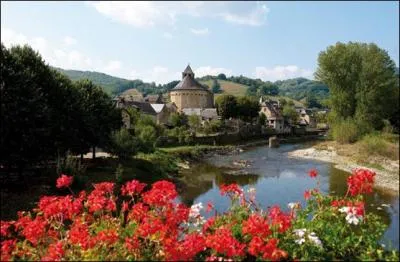 Quel est ce superbe village du département de l'Aveyron qui offre un joli panorama sur la haute vallée du Lot dont l'église déjà mentionnée en 909 possède un choeur roman entouré d'imposantes colonnes ?