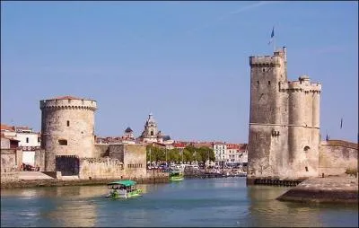 Deux tours médiévales gardent l'entrée du Vieux-Port de la Rochelle. Une grosse horloge leur fait face.