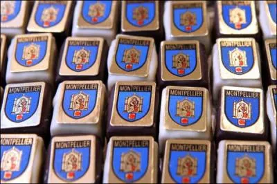 Ganache au Grand-Marnier mélangée à une crème d'amande et saupoudrée d'écorces d'oranges hachées. 'L'Écusson de ...', enrobé de chocolat blanc à la base existe aussi en version chocolat noir pour le grand plaisir des habitants de cette ville de l'Hérault !