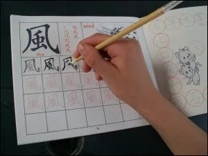 Cet enfant fait ses devoirs. Sur quoi écrit-il ?