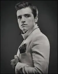 Qui demande à Peeta de défaire sa fermeture dans l'ascenseur ?