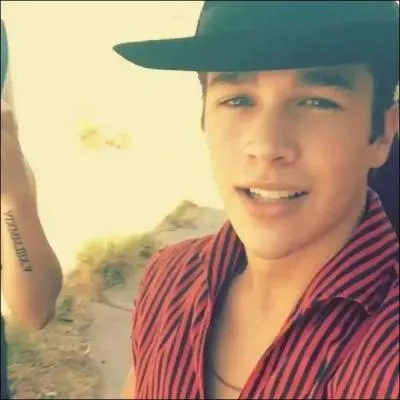 À qui appartient le tatouage que l'on aperçoit à gauche de cette photo ?