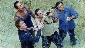 Qui est le personnage qui a une mitraillette et qui est en beige sur la photo ?