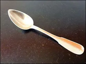 Comment la cuillère doit-elle être disposée sur la table ?