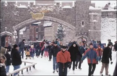 La Porte St-Jean à Québec est une des portes des fortifications de la ville. Québec est la dernière ville qui a gardé ses fortifications en Amérique. On la voit ici en hiver mais qu'est-ce qui est étrange dans la rue ?