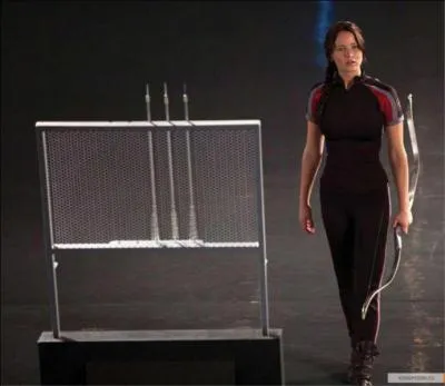 Pourquoi Katniss tire-t-elle dans la pomme vers les juges lors de ses minutes de démonstration personnelle avant les jeux ?