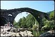 Ce pont de trois arches en pierre sur le rio Sella a été construit au XIVe siècle en Asturies à :