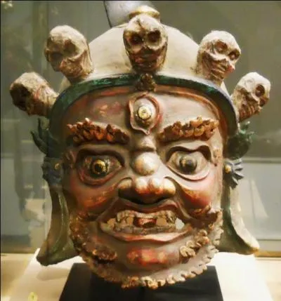 Le Gompo est un protecteur de la religion représenté avec une couronne de tête de morts, des crocs et une langue tirée. Quelles sont les cinq perturbations mentales représentées par les crânes ?